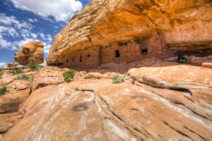 brick cliff dwellings underneath a large red rock overhang
