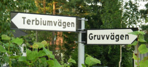 A road sign marking an intersection near the Ytterby mine. Translated from the original Swedish, it reads "Terbium Road" and "Mine Road"