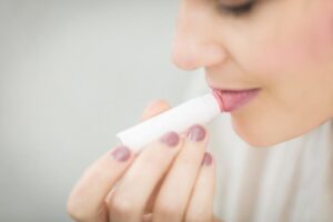 person applying lip balm